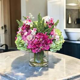 Pink and green floral arrangement in a clear glass vase