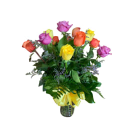 Bouquet of multicolored roses in a glass vase with a yellow ribbon
