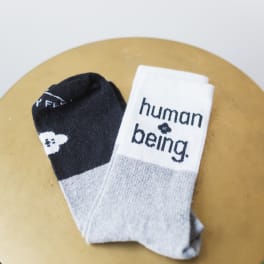 Pair of black and white socks with text on a round surface