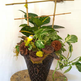 Potted plant arrangement with decorative birds and bamboo stakes