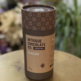Cylindrical cocoa mix container with brown label on a table