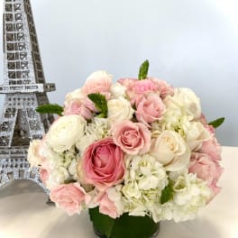 Pink and white rose bouquet in a low glass vase