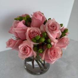 Pink roses arranged in a clear glass vase
