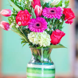 Pink and white mixed bouquet in a striped glass vase