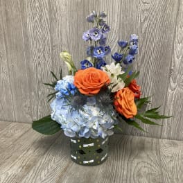 Blue hydrangea and orange roses in a decorated container