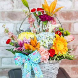 Colorful mixed flower basket with a blue bow