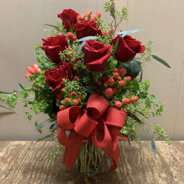 Red roses in a glass vase with a large red ribbon