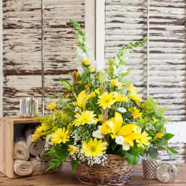 Yellow lilies and daisies arranged in a woven basket
