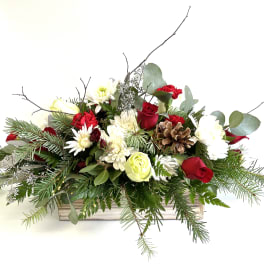 Holiday floral arrangement in a wooden box with red and white blooms