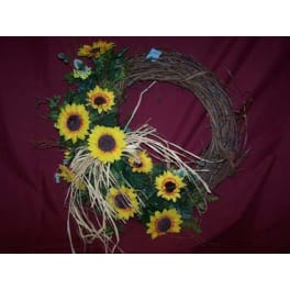 Sunflower wreath with straw accents on a burgundy background