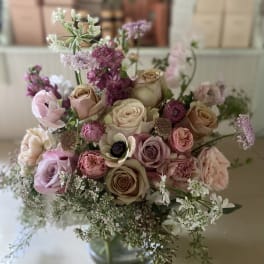 Mixed bouquet of pink and cream roses in a glass vase