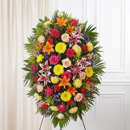 Standing floral spray with roses, lilies, and chrysanthemums on an easel