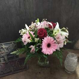 Pink and white mixed flower arrangement in a glass vase