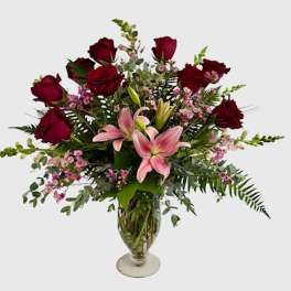 Bouquet of red roses and pink lilies in a glass vase