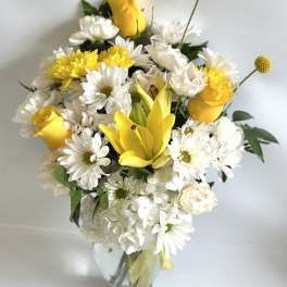 Yellow roses and white daisies in a glass vase