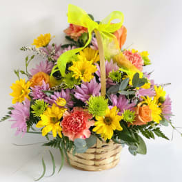 Basket of mixed flowers with a neon ribbon bow