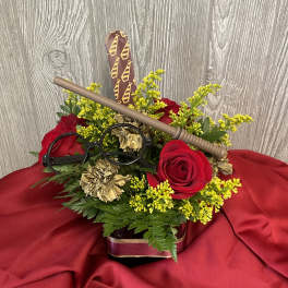 Red roses and yellow filler flowers in a decorative container with Harry Potter-themed accents