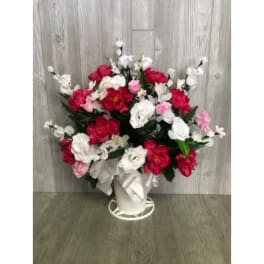 Bouquet of red, white, and pink flowers in a white container