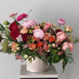 Mixed bouquet of roses and ranunculus in a silver vase