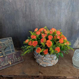 Orange rose bouquet in a stone-textured container