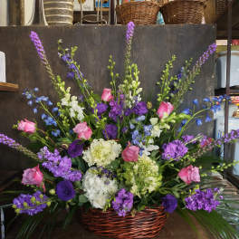 Basket arrangement of pink and purple flowers with white blooms