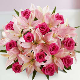 Pink roses and pale pink lilies arranged in a bouquet