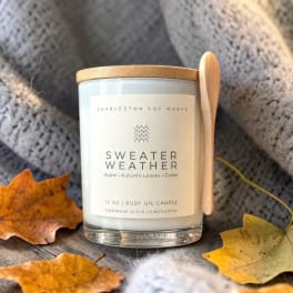 Autumn-scented candle in a glass jar with a wooden lid and spoon
