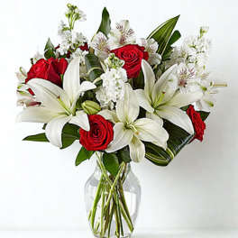 Red roses and white lilies in a clear glass vase