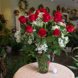 Bouquet of red roses and baby's breath in a clear glass vase