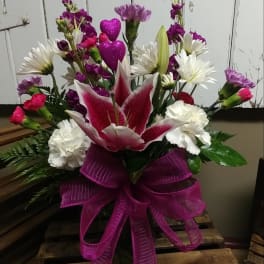 Pink and white mixed flower arrangement with a large ribbon bow