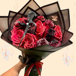 Bouquet of glittery red roses wrapped in black paper with a ribbon