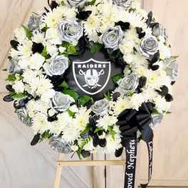 Black and white floral wreath with a Raiders logo in the center