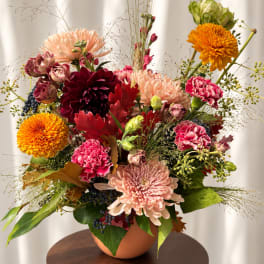 Mixed bouquet of chrysanthemums and carnations in a terracotta vase