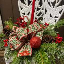 Christmas centerpiece with pine, berries, pinecones, and a red candle