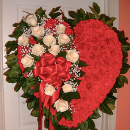 Heart-shaped floral spray with white roses and a red bow