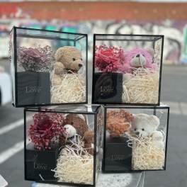 Gift boxes with teddy bears and small rose arrangements