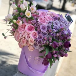Lavender hatbox arrangement of pink and purple roses with tulips