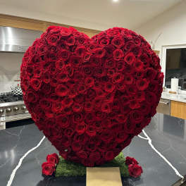 Heart-shaped arrangement of red roses on a kitchen counter