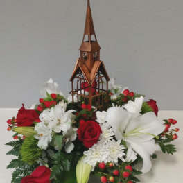 Red and white floral arrangement with a wooden church centerpiece