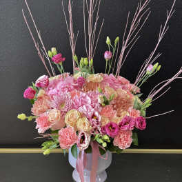 Pink and cream mixed bouquet in a white vase with tall decorative branches