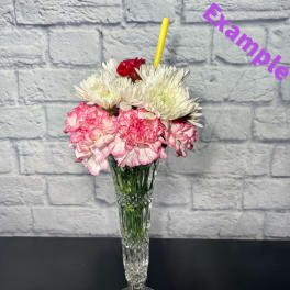 Pink and white carnations in a tall clear glass vase