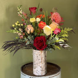 Mixed bouquet with roses and carnations in a birch-style vase