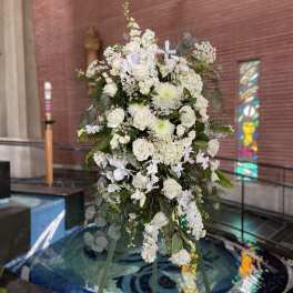 Tall white floral standing spray on an easel