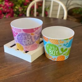 Two baby shower paper cups reading It's a Girl and It's a Boy
