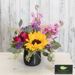 Mixed bouquet with a sunflower in a black vase