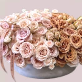 Large bouquet of pale pink and tan roses in a round vase