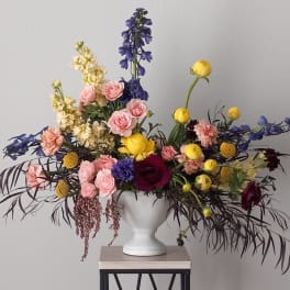 Colorful mixed flower arrangement in a white vase
