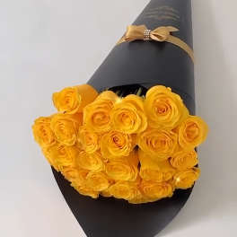 Bouquet of yellow roses wrapped in black paper with a gold ribbon