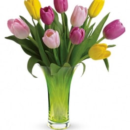 Bouquet of pink and yellow tulips in a clear glass vase