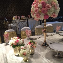 Pink and white floral centerpieces on a decorated banquet table